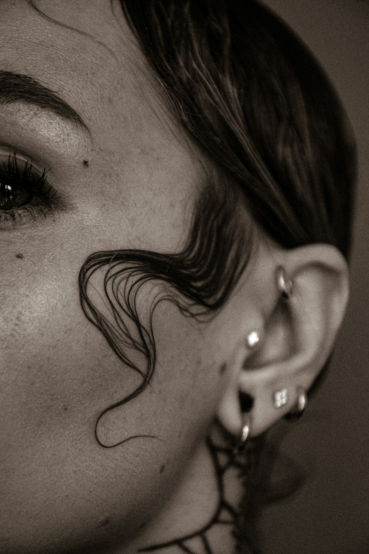 Woman's ear with a tragus piercing and several fine jewels on the cartilage.