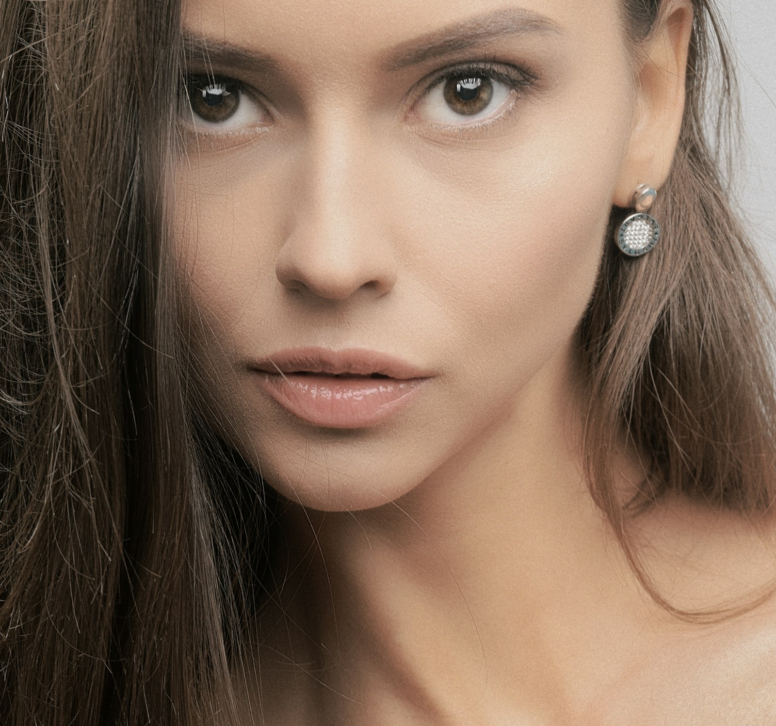 Boucles d'oreilles dépareillées asymétriques posées sur fond clair, style original et féminin.