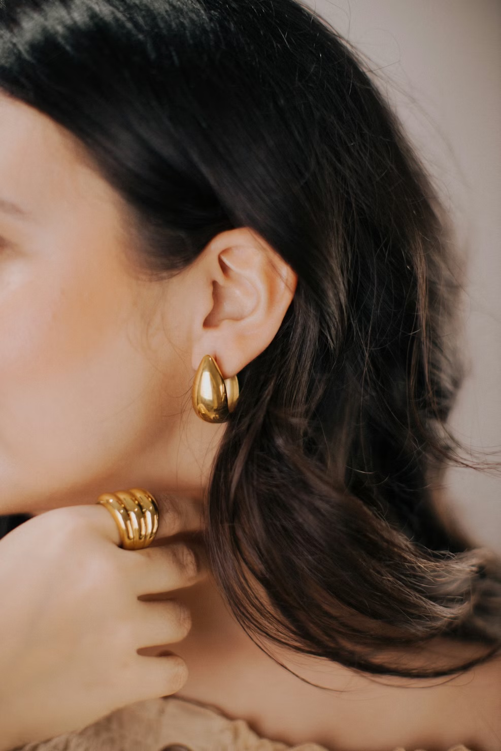 Pair of gold earrings placed on light fabric