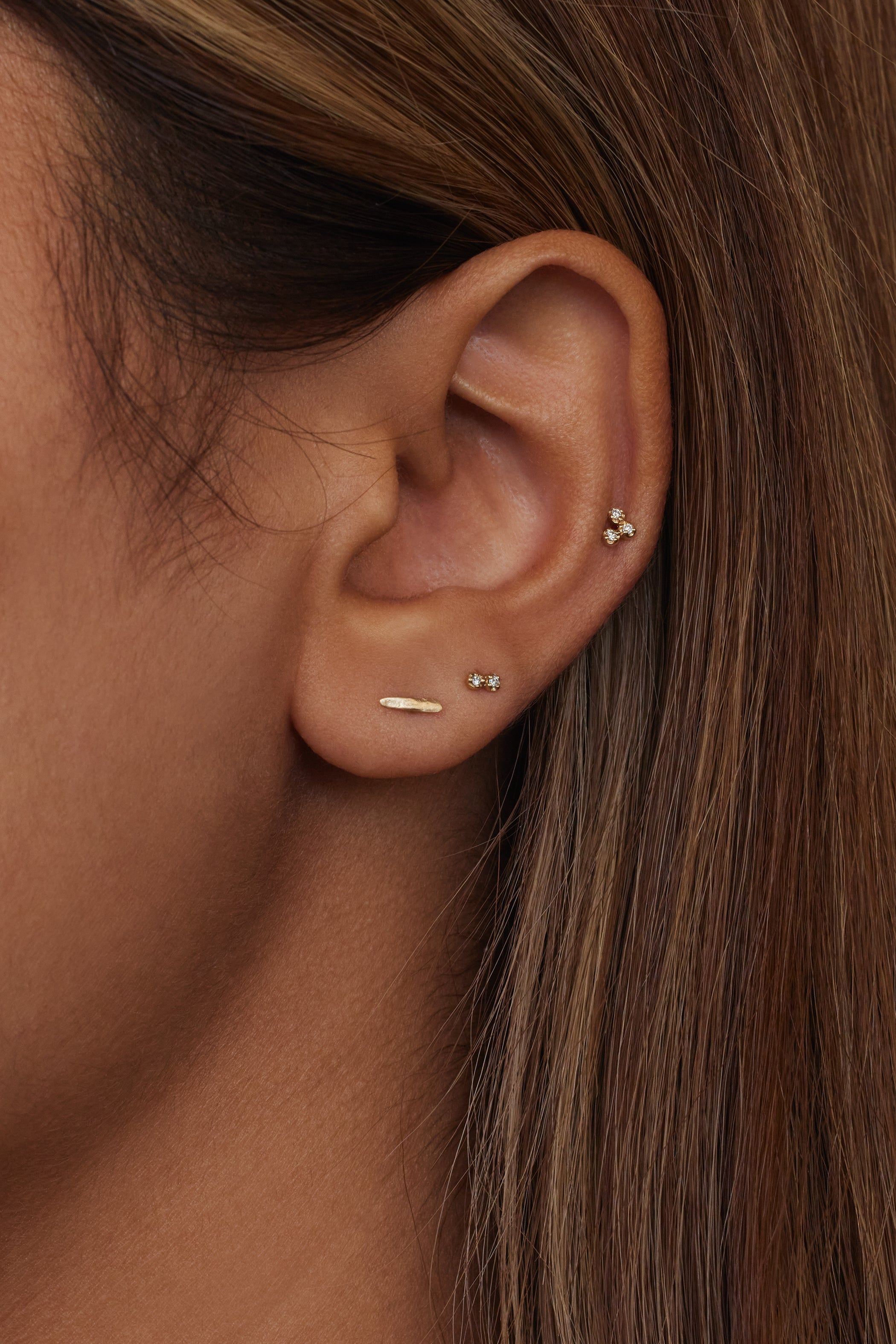 Oreille avec plusieurs piercings sur le cartilage et le lobe