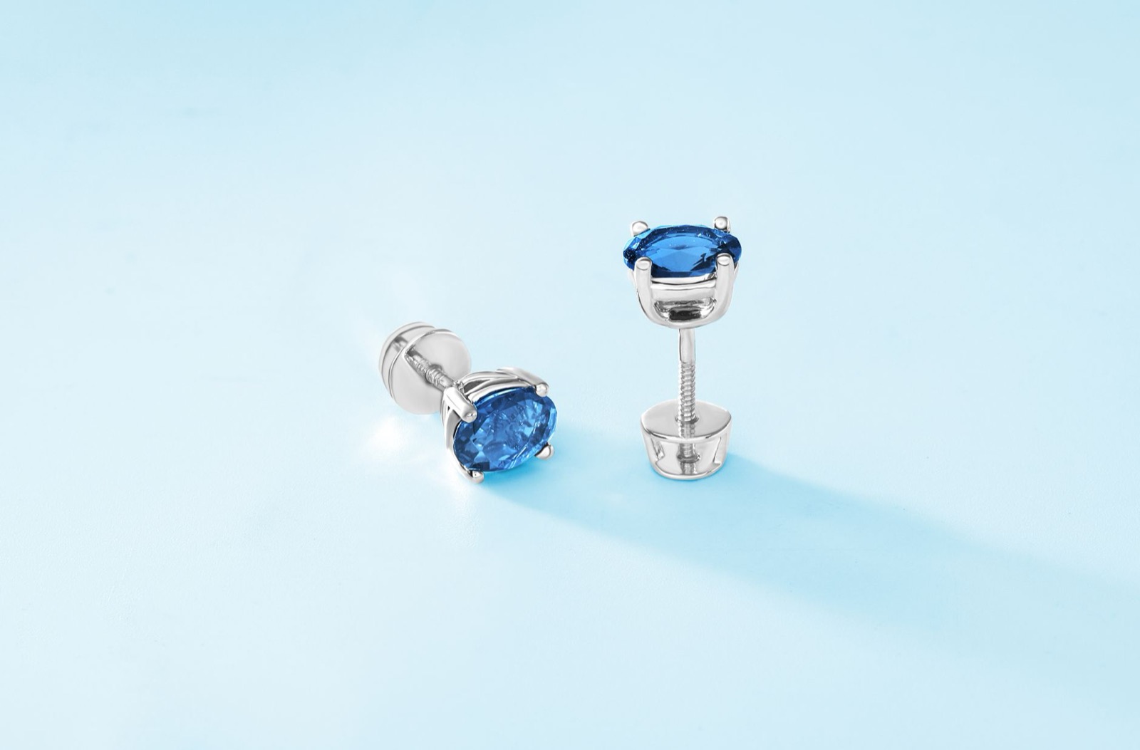 Puces d’oreilles en argent serties de pierres bleues sur fond clair