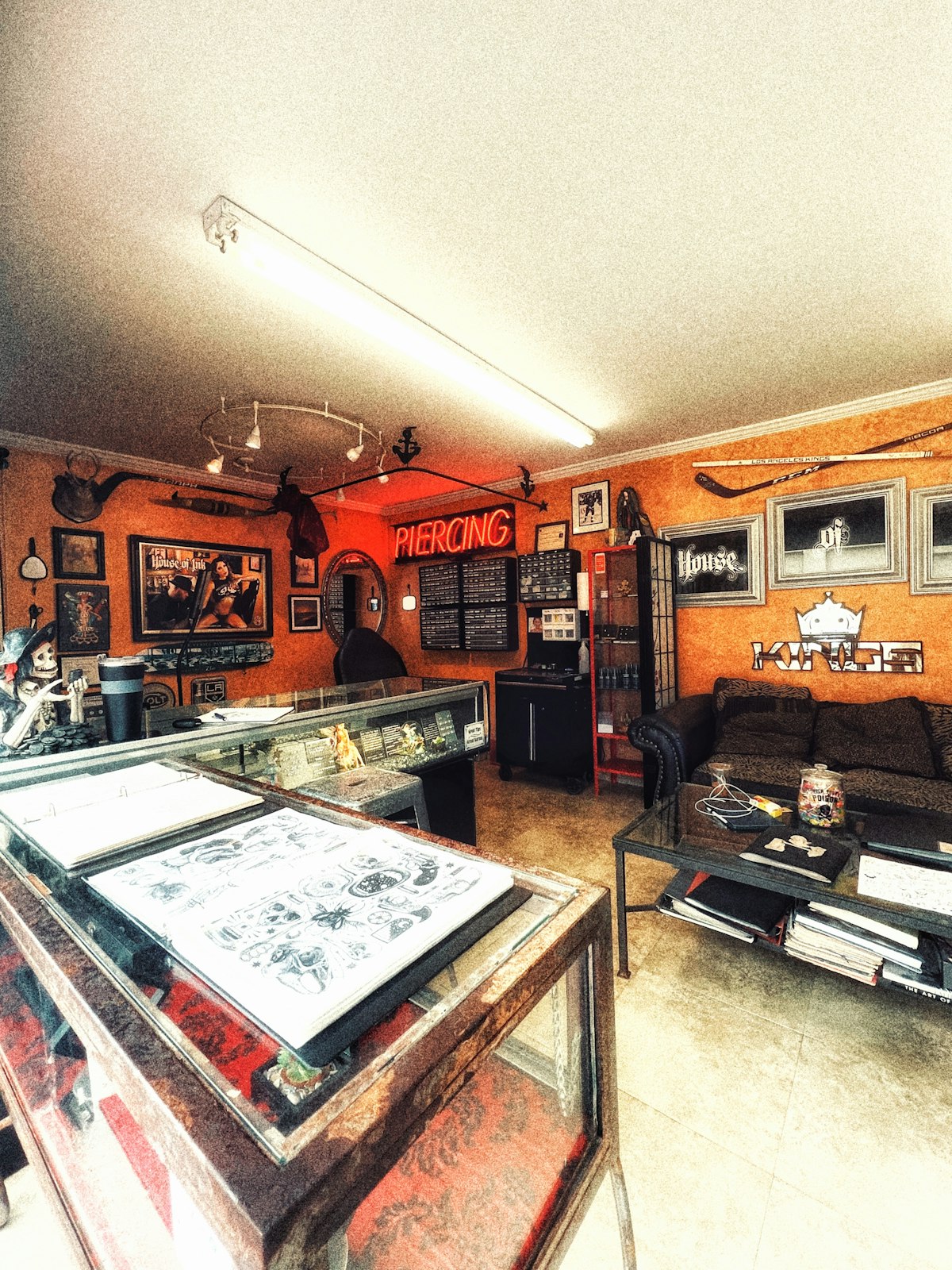 Piercing salon interior with a neon sign, jewelry display cases and a waiting area.