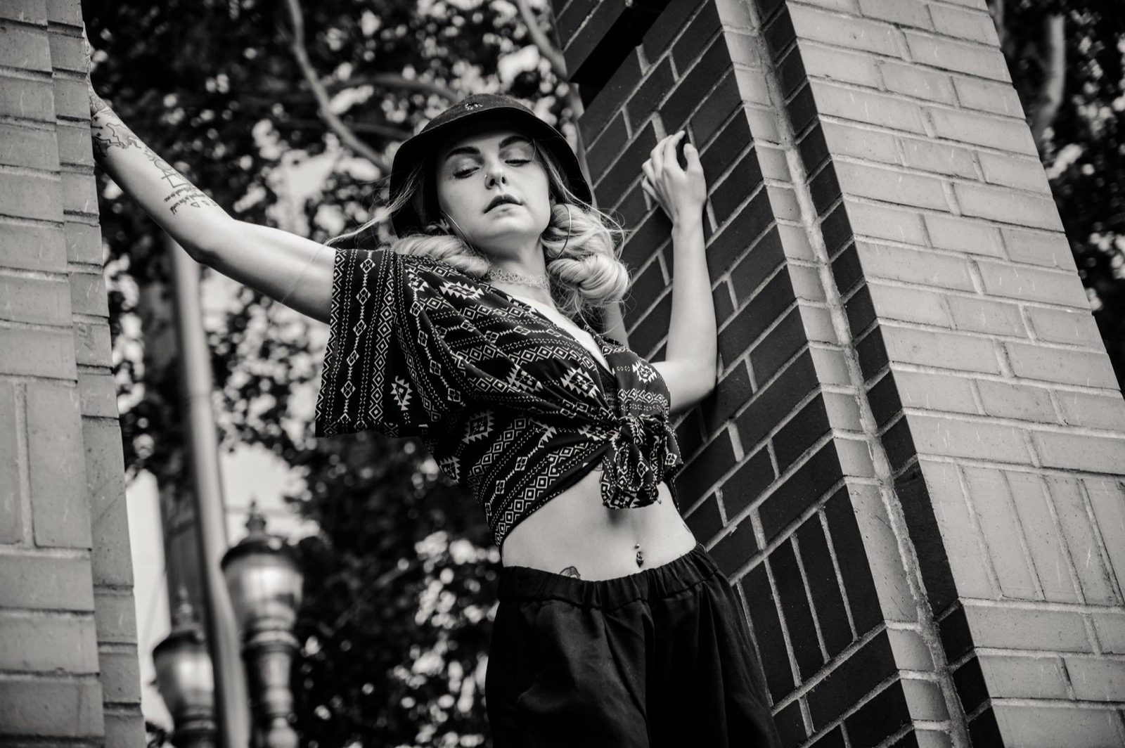 Black and white portrait of a woman wearing a belly button piercing and a knotted crop top